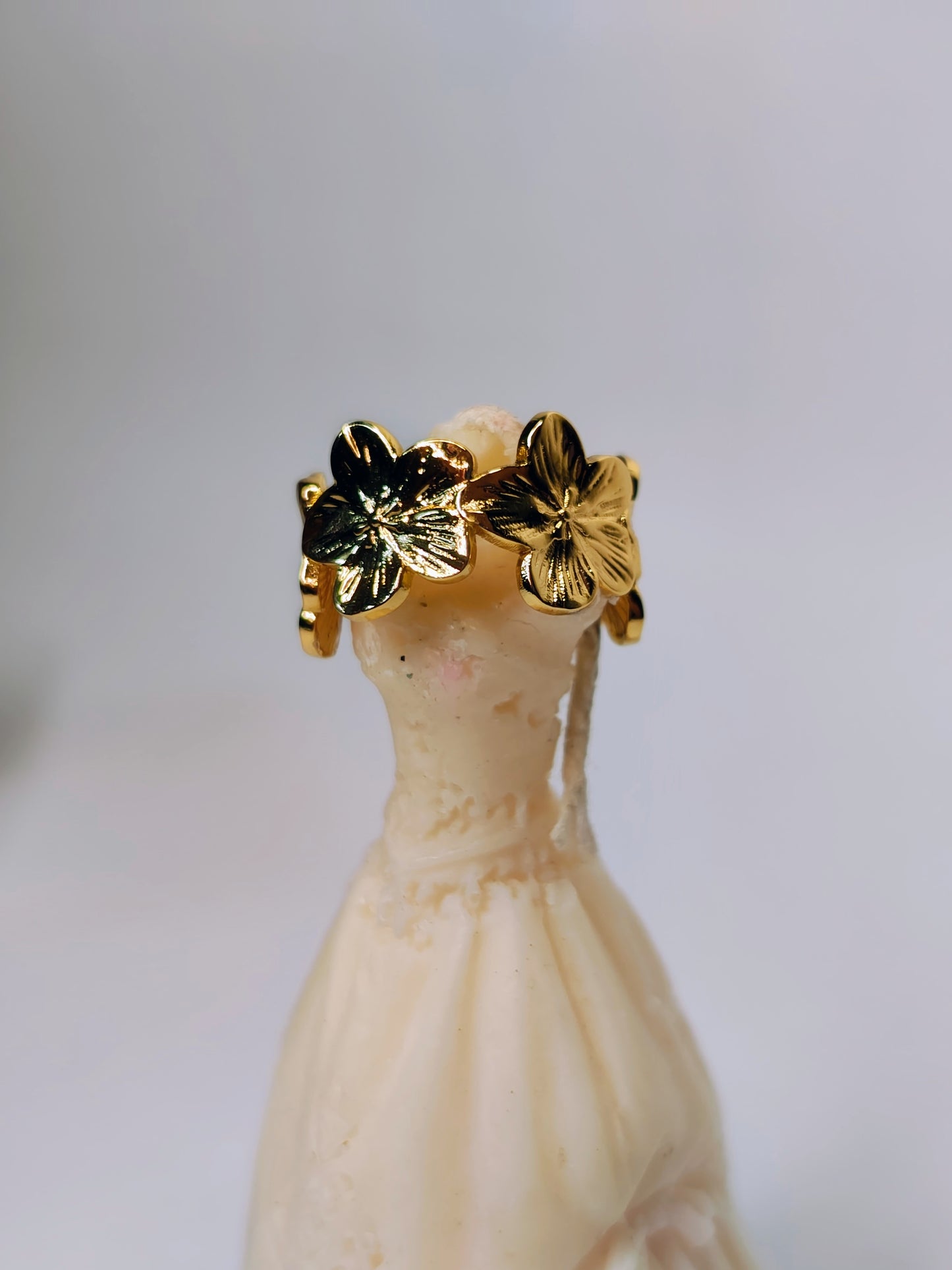 Gold leaf earrings on a mannequin head with a blurred background